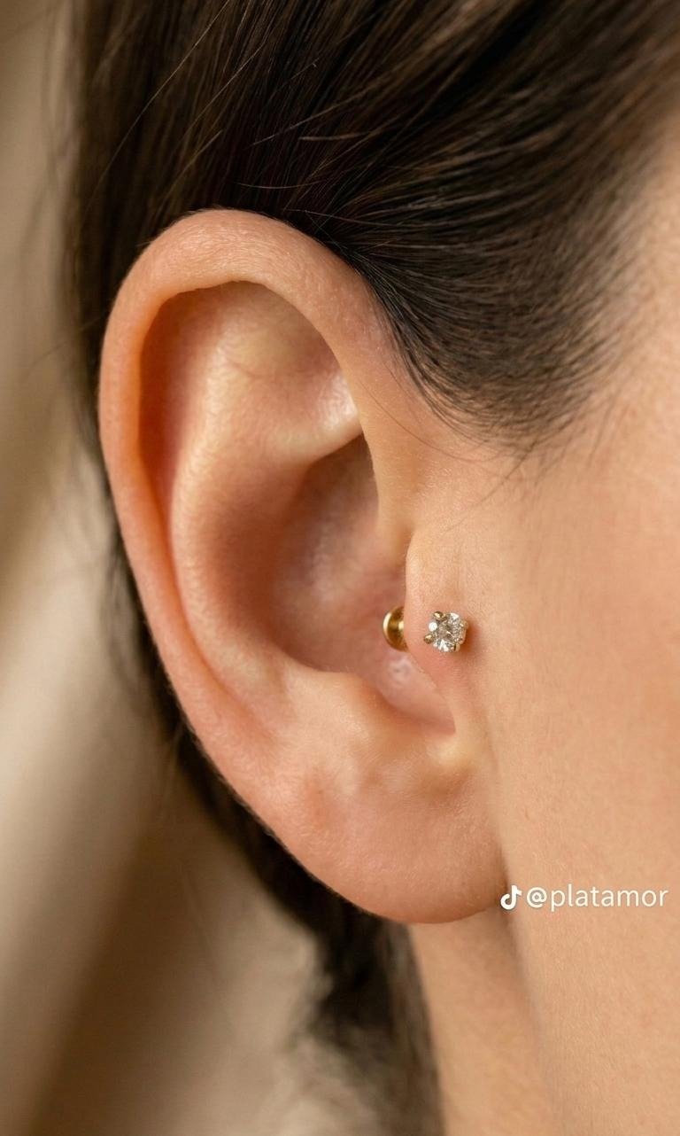 Piercing de oro 10K con piedra brillante colocado en el tragus