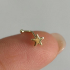 Piercing estrella de oro 10K Pier210k sobre la yema de un dedo