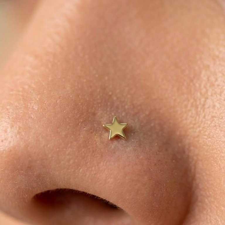 Piercing de estrella dorada colocado en la nariz