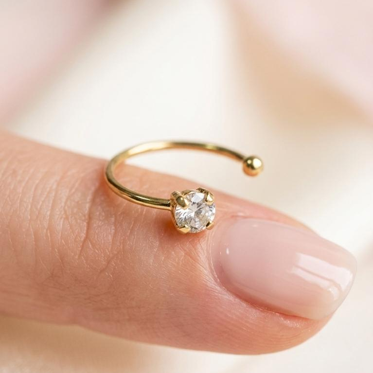 Piercing de aro con piedra transparente Pier310k sobre un dedo