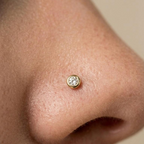 Detalle del piercing de oro 10K con piedra brillante colocado en la nariz