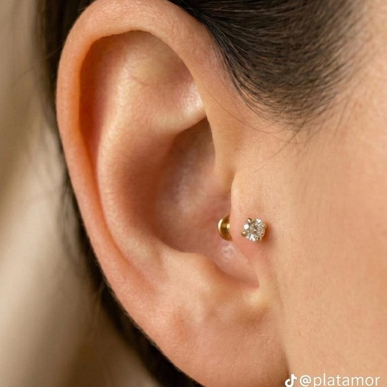 Piercing de oro 10K con piedra brillante colocado en el tragus